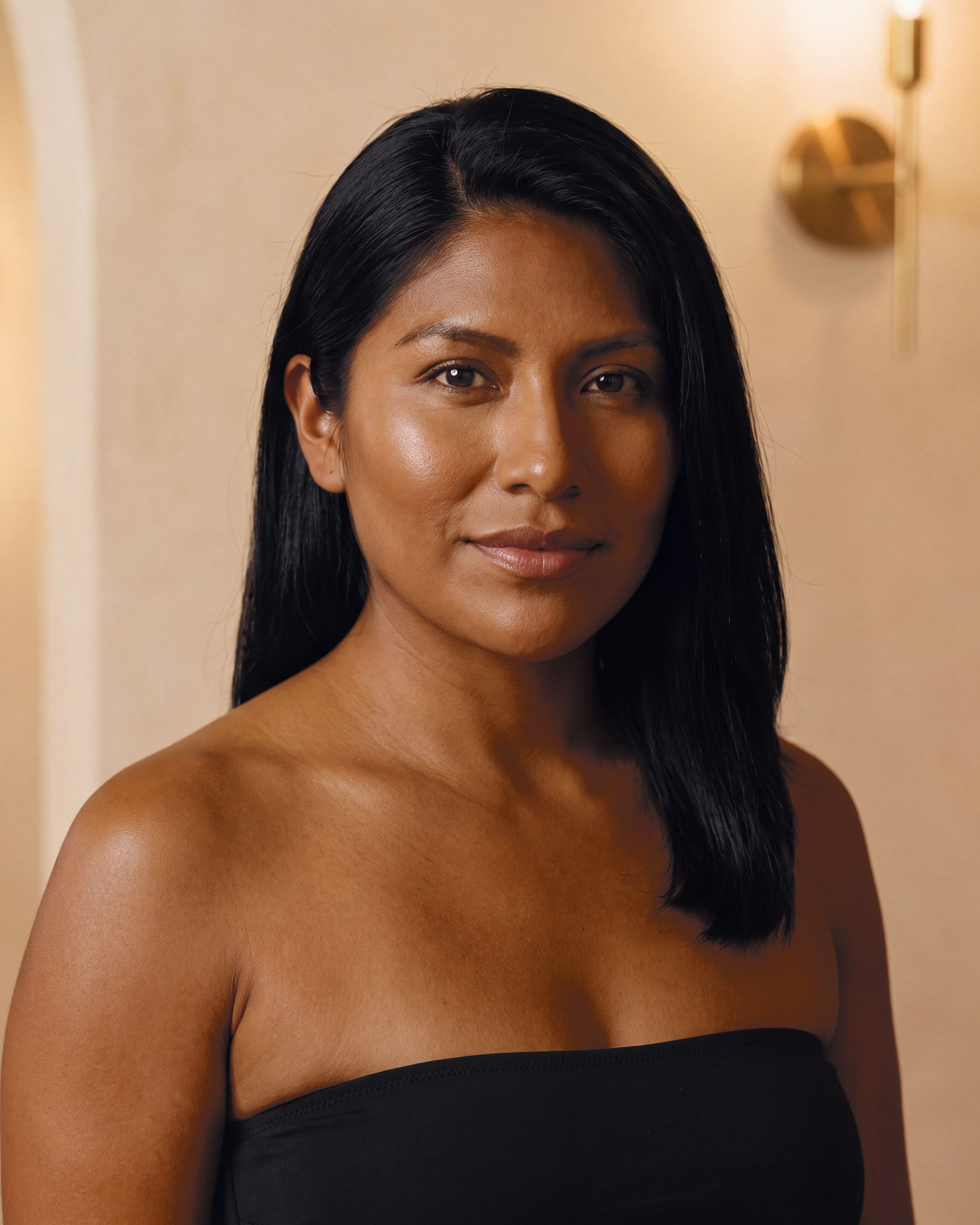 AI rendering: the same woman with olive skin after a deeper custom spray tan