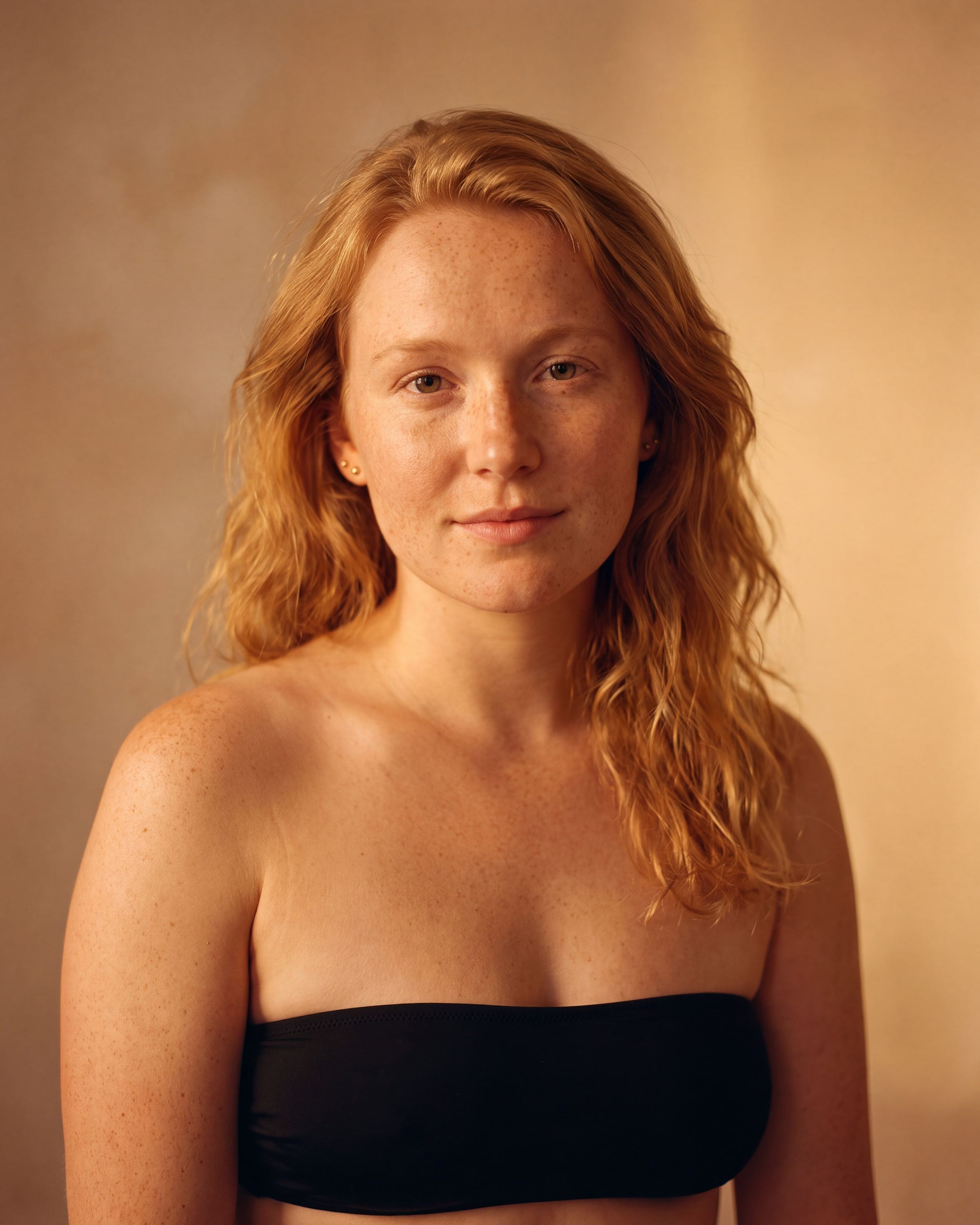 AI rendering: the same woman with fair, freckled skin after a warm custom spray tan